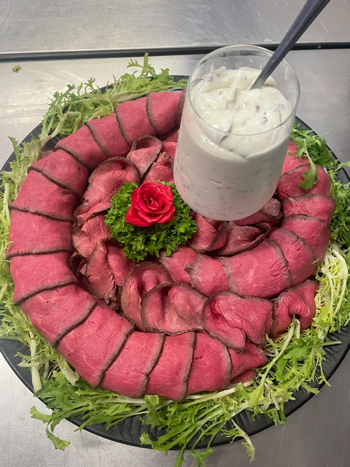Roastbeef auf einer runden Platte mit Dip und Salat